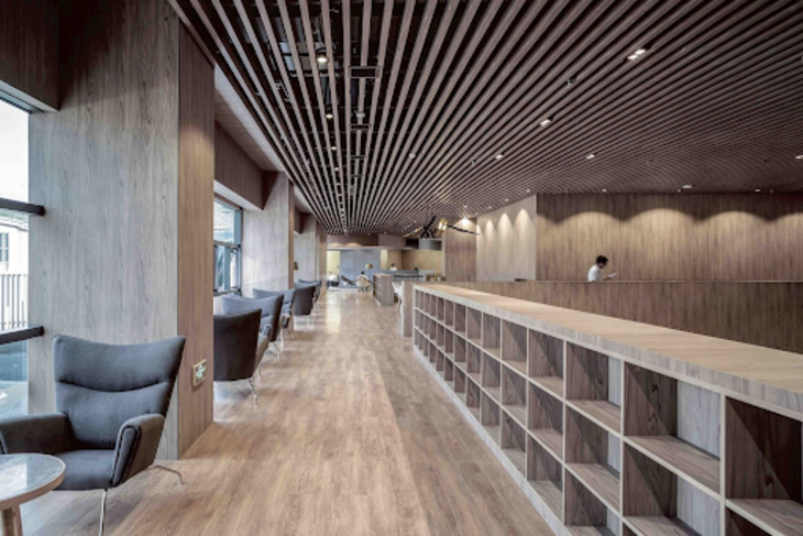 Mẫu trần nhôm giả gỗ U-Shaped được thiết kế đồng bộ với nội thất tại hành lang một nhà hàng cao cấp