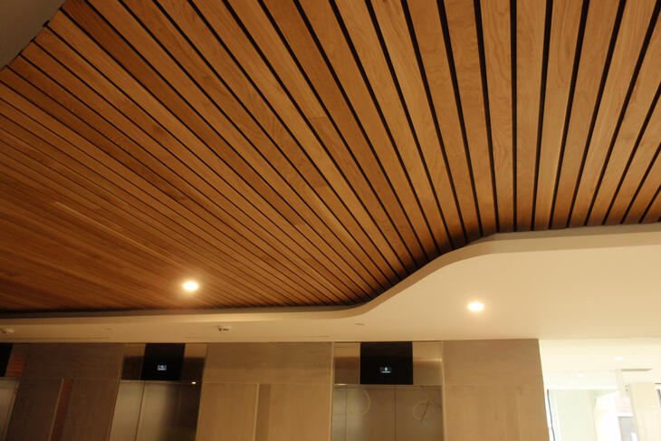 Với công trình có diện tích lớn, trần nhôm giả gỗ với các gam màu trầm hơn như nâu đất, nâu đen là một lựa chọn hoàn hảo