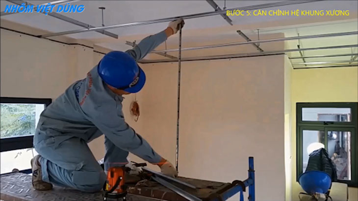 Bước 5 trong quy trình cách làm trần nhôm: Căn chỉnh hệ khung xương sao cho mặt phẳng khung thẳng và đều nhất có thể