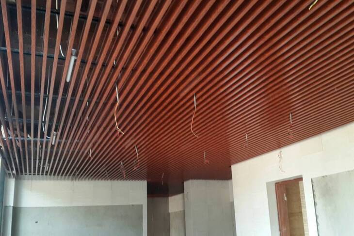 Thiết kế trần nhôm giả gỗ màu nâu đỏ đậm rất phù hợp cho những gia chủ mang mệnh hỏa