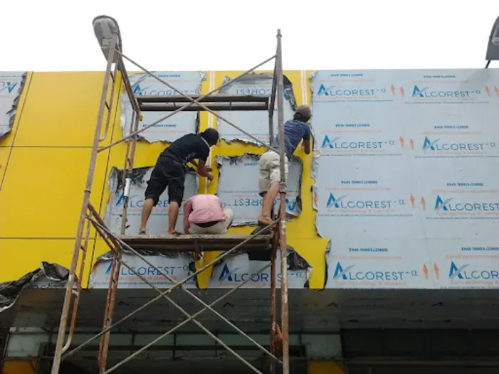 Tấm alu được cắt theo kích thước yêu cầu, sau đó ốp lên khung xương bằng vít và keo silicon. Các mối nối giữa các tấm alu cần được khít, không để lộ khe hở